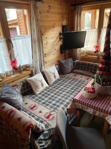 Zimmer mit einem Bett und einem TV in einer Hütte in der Unterkunft Hunting Lodge Lipót in Lipót