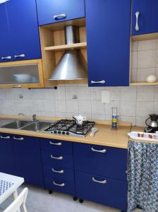 una cucina con mobili blu, una stufa e un lavandino di Casa della Sibilla a Napoli