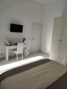 a bedroom with a bed and a desk and a television at Casa della Sibilla in Naples