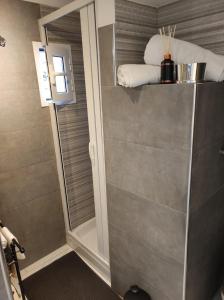 una doccia con una porta in vetro in un bagno di Casa della Sibilla a Napoli Altre 7 foto