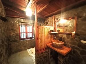 ein Badezimmer mit einer Schüssel auf einem Holzregal in einem Zimmer in der Unterkunft Puluong Home in Pu Luong