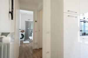 een hal met witte muren en een deur naar een badkamer bij Lora apartment,free private parking, self check in in Como +22 foto's