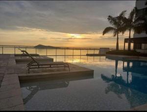 una piscina con un banco junto al agua en Departamento en la mejor zona de Guayaquil, en Guayaquil