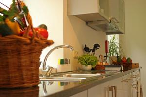 a kitchen with a sink and a basket of vegetables at Solar Arco de São Jorge in Santana