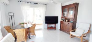 a living room with a table and a tv at Apartamento Dianium by DENIA COSTA in Denia