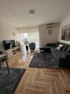 a living room with a couch and a flat screen tv at Apartman West - private parking place in Zagreb