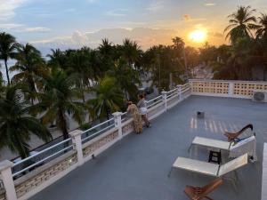 女人島的住宿－Antillas，两人站在阳台上欣赏日落美景
