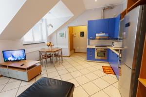 uma cozinha com armários azuis e uma mesa com um computador portátil em Residenza CONCORDIA em Sondrio
