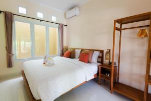 a bedroom with a large bed and a large window at Donguri House Bali in Jimbaran