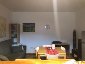 a living room with a table and a couch at La maison de Linanna in Aymavilles