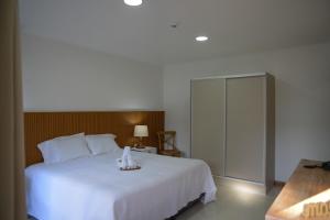 a bedroom with a large white bed and a cabinet at HAS Hotel Boutique in Bella Unión