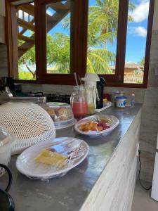 eine Küchentheke mit Teller mit Lebensmitteln darauf in der Unterkunft Vila Gará Kite House - Ilha do Guajiru in Itarema