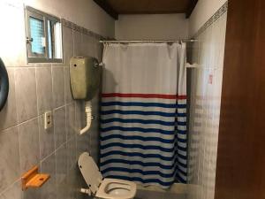 a bathroom with a toilet and a shower curtain at Casa ideal para pareja en Bella Vista - Maldonado in Bella Vista