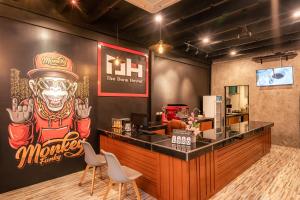 un ristorante con un bar con un cartello di scimmia sul muro di The Dorm Hostel a Ban Lo Long