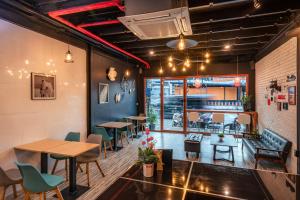 a restaurant with tables and chairs in a room at The Dorm Hostel in Ban Lo Long