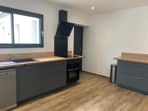 a kitchen with black cabinets and a sink and a window at Gîte Camdeborde 2 personnes au cœur du village de Laruns in Laruns