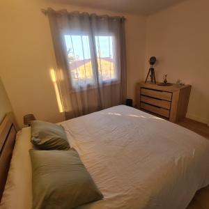 a bedroom with a large white bed with a window at Villa standing 10 personnes piscine/ pinède in Canet-en-Roussillon