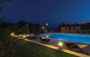 basen w nocy z krzesłami i światłami w obiekcie E&T apartments with a beautiful pool w Rabacu