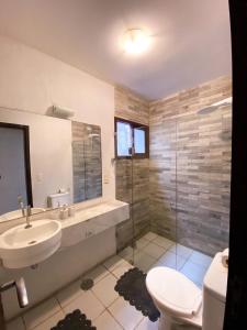 ein Bad mit einem Waschbecken, einem WC und einer Dusche in der Unterkunft Apartamentos Orrit Real Estate in Pipa