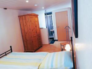 1 dormitorio con 1 cama y armario de madera en Ferienwohnung Langenhecke 16, en Bad Münstereifel