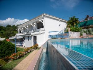 - une piscine en face d'une maison blanche dans l'établissement Résidence Madicréoles, à Le Carbet