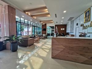 a lobby with a couch and tables and a lobby with a lobby at Sea Paradise Hotel Sattahip in Sattahip