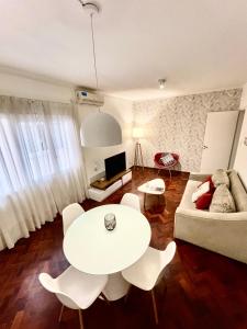 un soggiorno con tavolo e sedie bianchi di Mdz Apartments a Mendoza