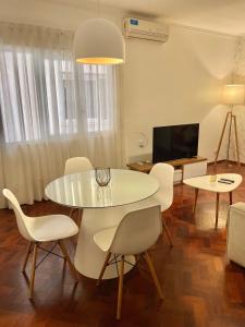 comedor con mesa blanca y sillas en Mdz Apartments en Mendoza
