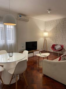 sala de estar con mesa, sillas y TV en Mdz Apartments en Mendoza