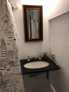a bathroom with a sink and a shower curtain at Hermosa casita con jardín Goldas Haus in Florida