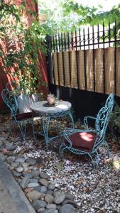 2 chaises et une table dans une arrière-cour avec une clôture dans l'établissement Hermosa casita con jardín Goldas Haus, à Florida