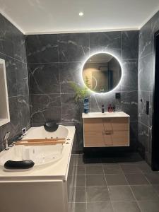 a bathroom with a tub and a sink and a mirror at Nytt moderne hus på Storsteinnes in Storsteinnes