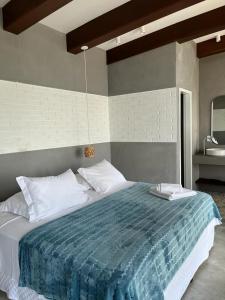 um quarto com uma cama grande e um cobertor azul em Villa dos Ganchos em Governador Celso Ramos