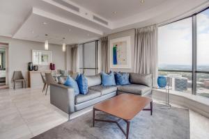 a living room with a couch and a table at Luxury Penthouse at Sandton Skye in Johannesburg