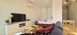 ポルトにあるMerc Porto Estudio 245のソファとテレビのあるリビングルーム