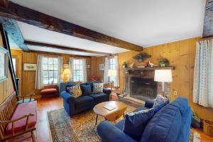 ein Wohnzimmer mit blauen Sofas und einem Kamin in der Unterkunft Easy Living in Plymouth