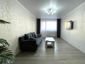 uma sala de estar com um sofá e uma mesa em Двухкомнатная квартира, новый ремонт, 2 этаж, центр em Petropavl