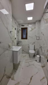 a marble bathroom with a toilet and a sink at Guest House Gogemi in Bansko