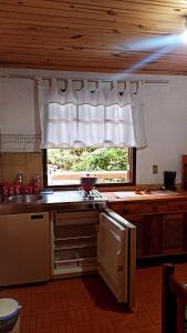 een keuken met een raam, een wastafel en een fornuis bij Casa da Roça in Visconde De Maua