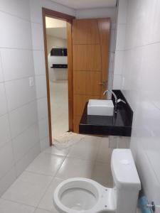 łazienka z toaletą i umywalką w obiekcie Praia de Setiba - Kitnet w mieście Guarapari