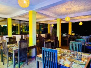 um restaurante com mesas e cadeiras com comida em Grand Adamspeak em Nallathanniya