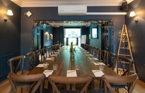 a long table in a room with chairs and lights at The Georgian Townhouse in Norwich