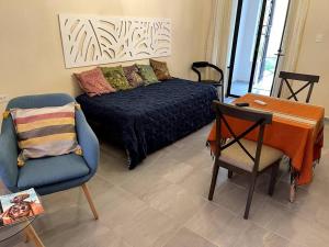 ein Wohnzimmer mit einem Bett, einem Stuhl und einem Schreibtisch in der Unterkunft Villa Candita, a unos pasos del Paseo Montejo in Mérida + 56 Fotos