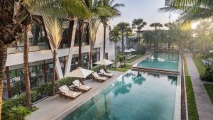 uma vista aérea de um hotel com palmeiras e uma piscina em Anansaya La Maison em Siem Reap