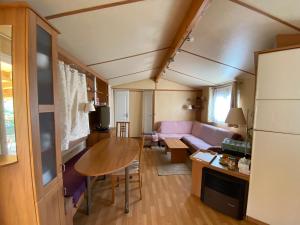 a living room with a couch and a table at Charmant Mobile-home 6 personnes sur terrain privé à 200 m de la plage - PADRIG in Ploemeur
