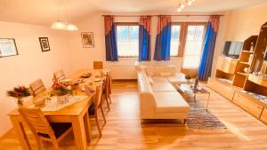 een woonkamer met een bank en een tafel en stoelen bij Haus Dekorso in Dorfgastein