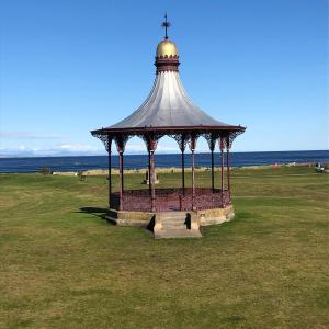 a gazebo in a field next to the ocean at Corsee House in Nairn