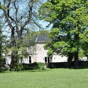 una vieja casa blanca con árboles en un campo en Corsee House, en Nairn