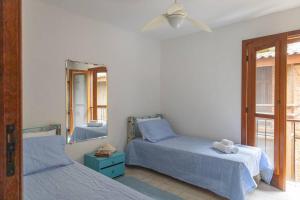 a bedroom with two beds and a mirror at CASA DA ILHA em CONDOMINIO in Ilhabela +64 photos