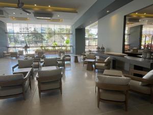 una sala de espera con mesas y sillas en un restaurante en Santa Marta Condominio Reserva del Mar Playa Salguero frente al Mar, en Santa Marta